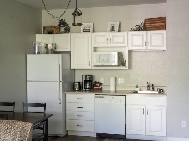 kitchen with dark hardwood / wood-style flooring, sink, white cabinets, and white appliances