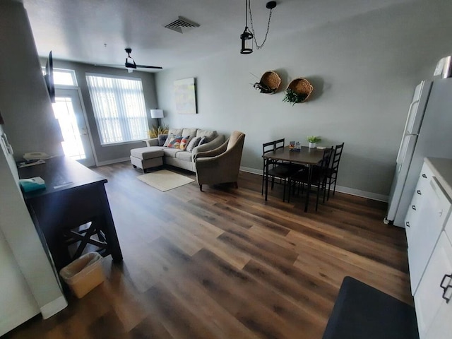 living room with ceiling fan and dark hardwood / wood-style flooring