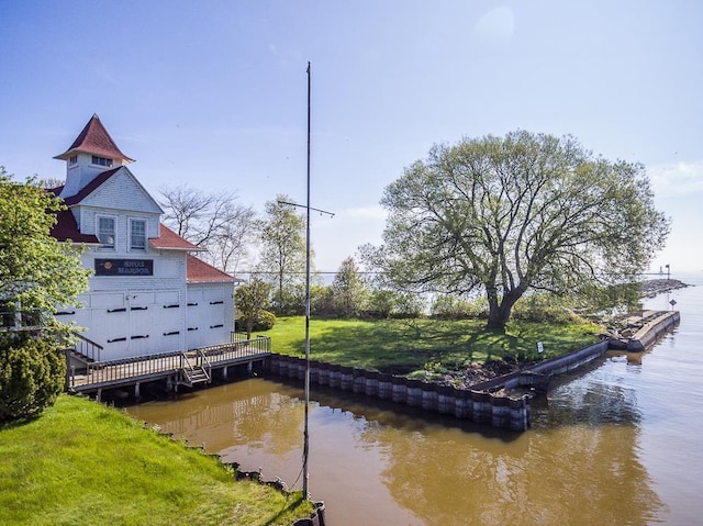 view of dock with a water view and a lawn