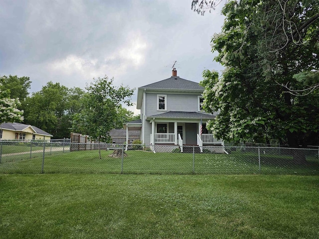 back of house with a lawn and covered porch