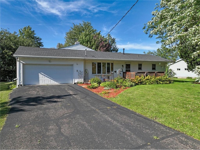 single story home with a deck, a front yard, and a garage