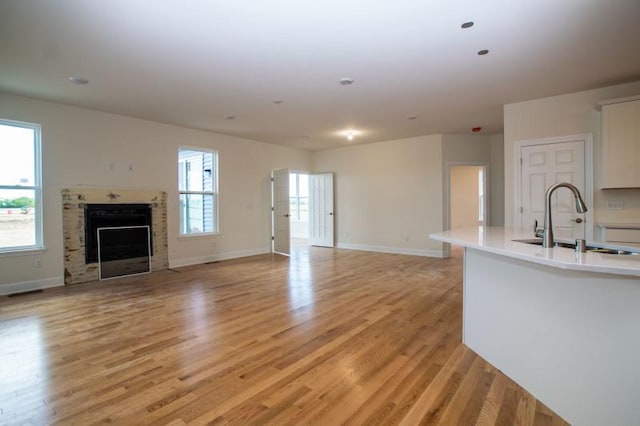 unfurnished living room with light hardwood / wood-style floors and sink