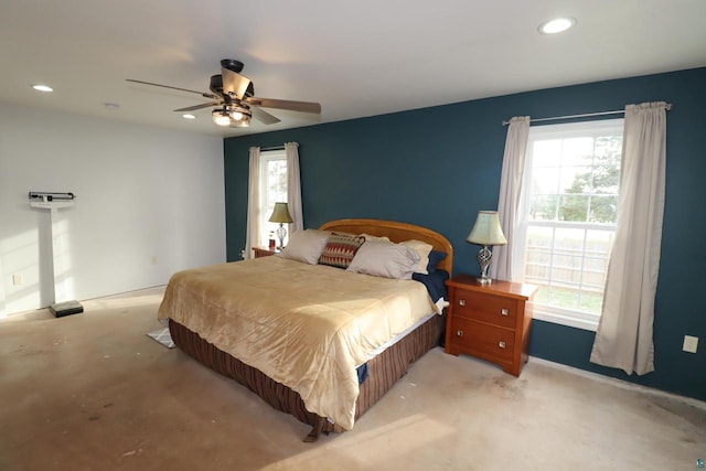 carpeted bedroom featuring ceiling fan and multiple windows