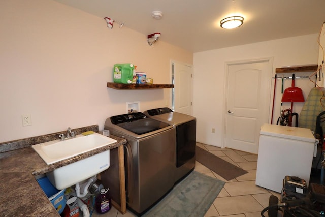 washroom featuring washer hookup, washing machine and dryer, light tile floors, and sink