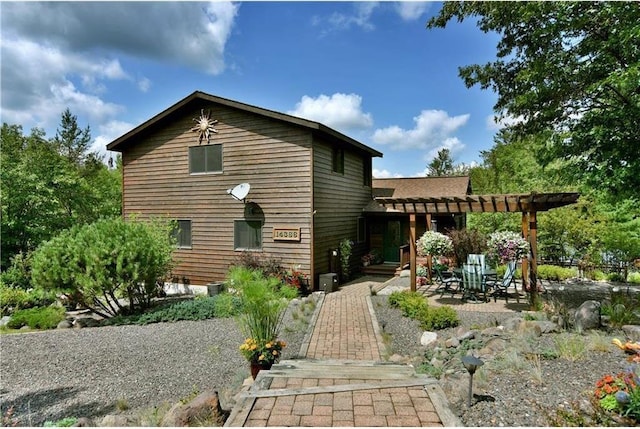 rear view of property featuring a patio area and a pergola