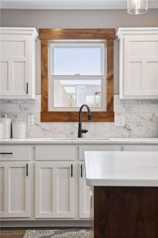 kitchen with tasteful backsplash, sink, and white cabinets