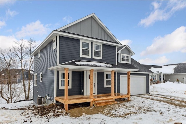 view of front of home with a garage, central air condition unit, and covered porch