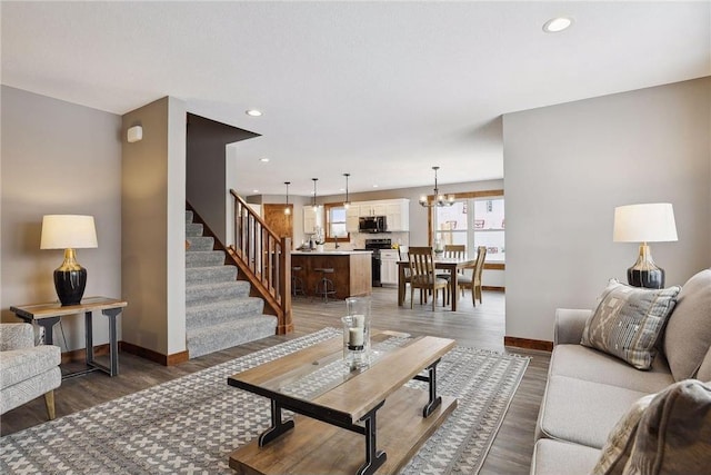 living room featuring an inviting chandelier and dark hardwood / wood-style flooring