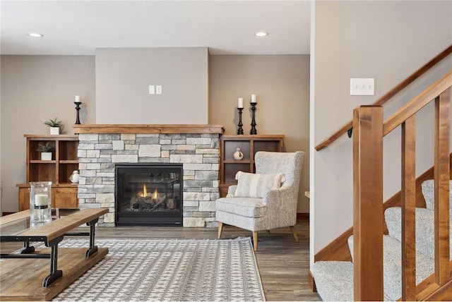 sitting room featuring hardwood / wood-style flooring and a stone fireplace