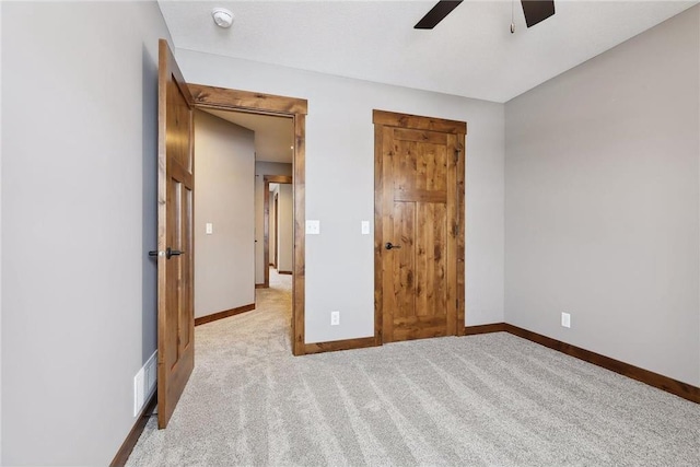 unfurnished bedroom featuring light carpet and ceiling fan