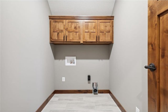 clothes washing area with cabinets, hookup for an electric dryer, hookup for a washing machine, and a textured ceiling