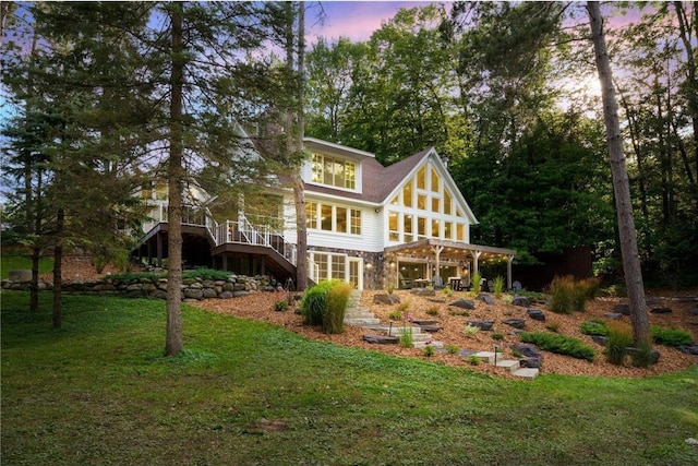 back house at dusk with a lawn