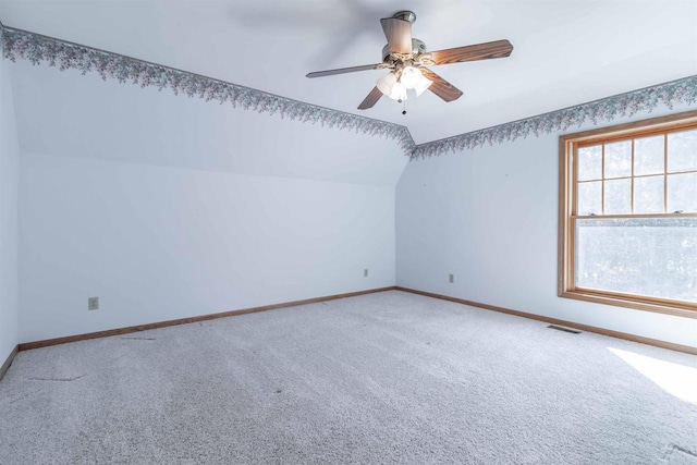 empty room with ceiling fan, light carpet, and vaulted ceiling