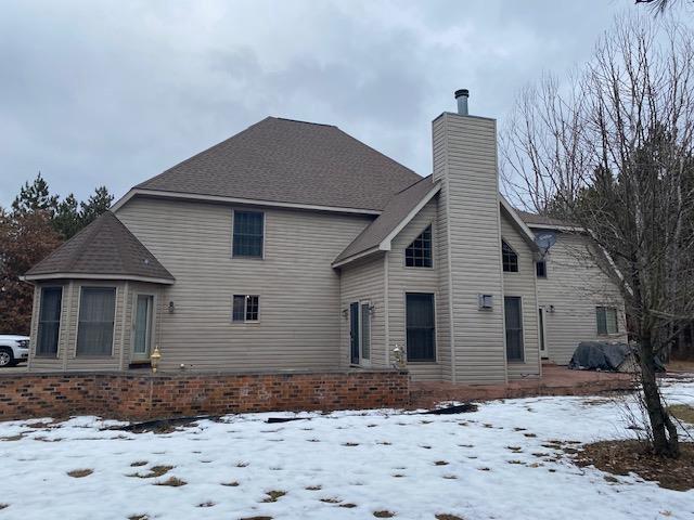 view of snow covered back of property