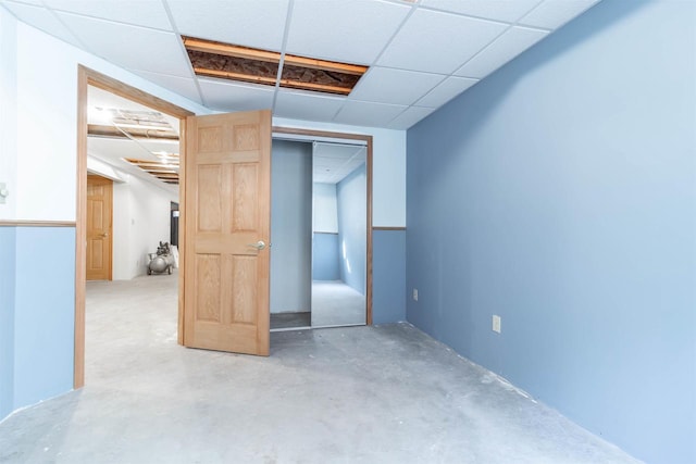 unfurnished bedroom featuring a paneled ceiling and a closet