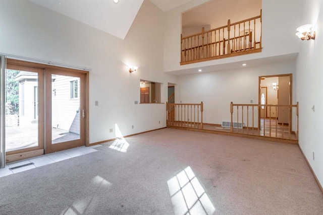 interior space featuring a towering ceiling and light colored carpet