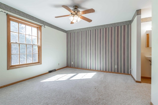 carpeted spare room with ceiling fan and sink