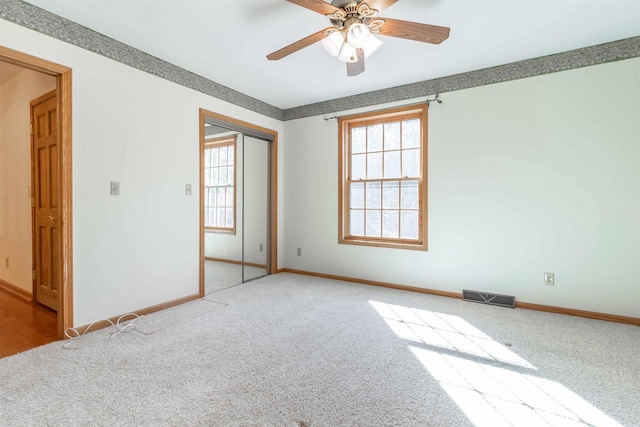 spare room featuring ceiling fan and light carpet