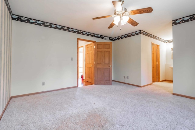 unfurnished bedroom featuring ceiling fan, ensuite bath, and light carpet