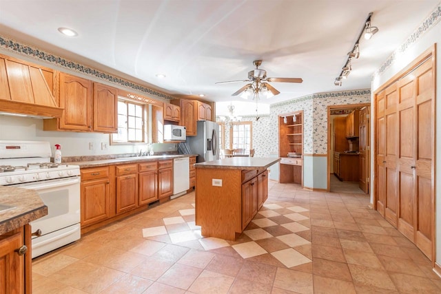 kitchen featuring a kitchen island, white appliances, ceiling fan, and light tile floors