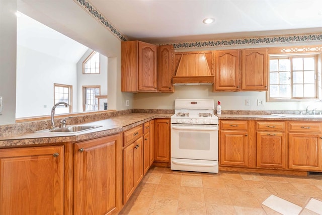 kitchen featuring a healthy amount of sunlight, premium range hood, sink, and white gas stove