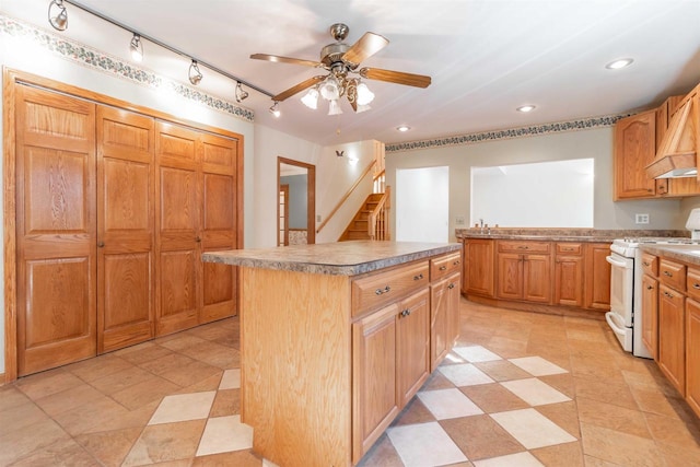 kitchen with light tile floors, a center island, ceiling fan, premium range hood, and white range oven