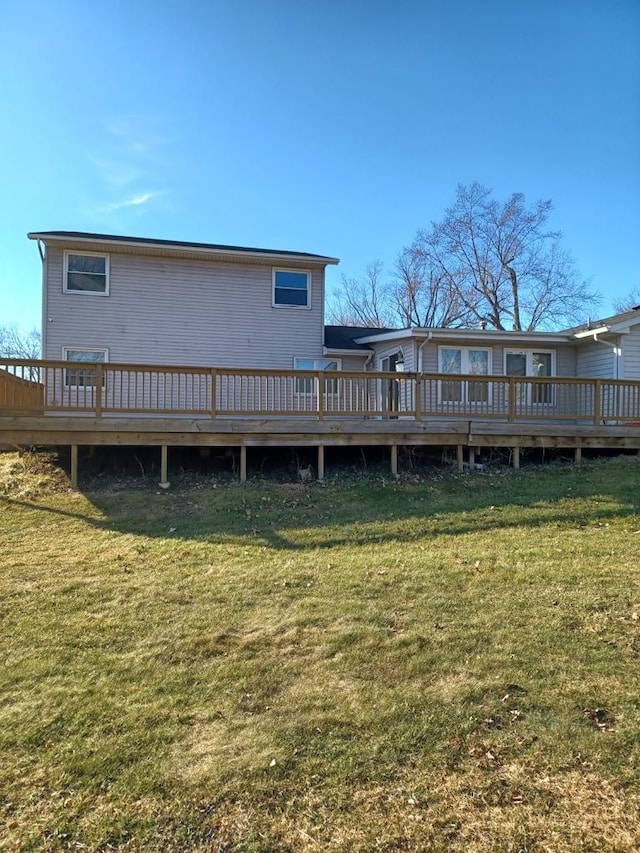 rear view of property featuring a wooden deck and a yard