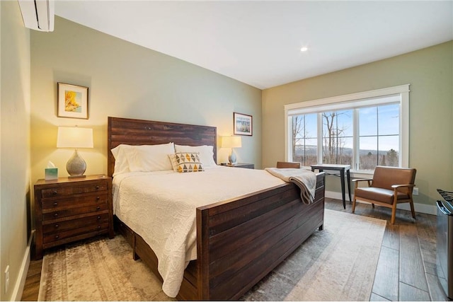 bedroom featuring a wall mounted air conditioner and light wood-type flooring