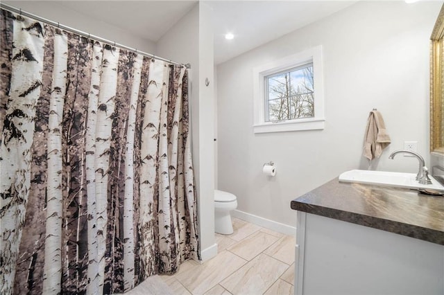 bathroom featuring toilet, vanity, and tile flooring