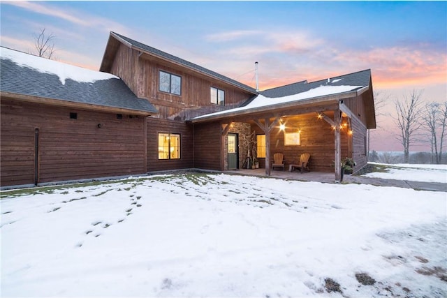 view of snow covered back of property