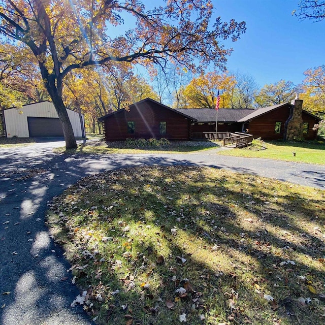 view of front facade with a garage, a front yard, and an outdoor structure