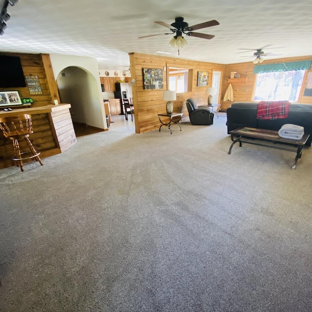 interior space with ceiling fan and wooden walls