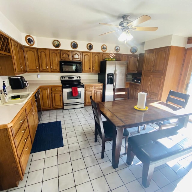 kitchen featuring sink, ceiling fan, light tile floors, and black appliances