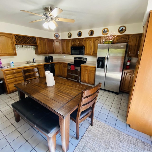 kitchen with sink, ceiling fan, black appliances, and light tile floors