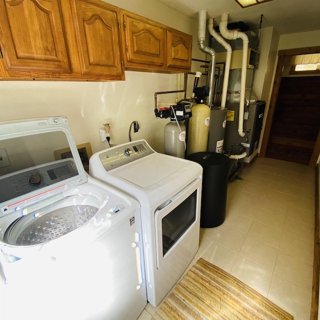 laundry room featuring hookup for an electric dryer, cabinets, light tile floors, and washer and clothes dryer