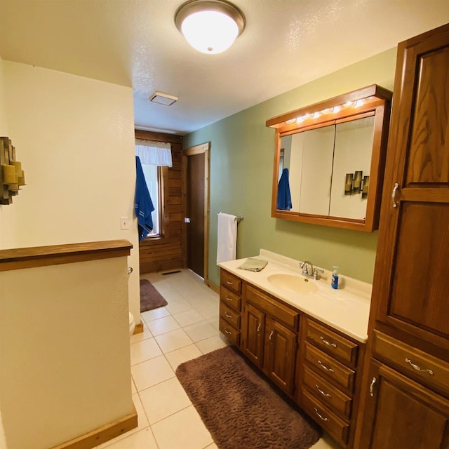 bathroom with tile flooring, vanity, and a textured ceiling