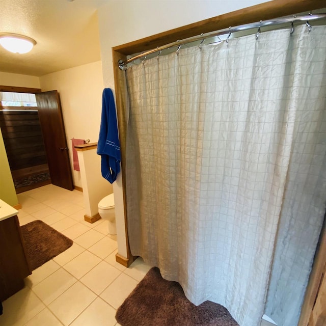 bathroom with vanity, toilet, and tile floors