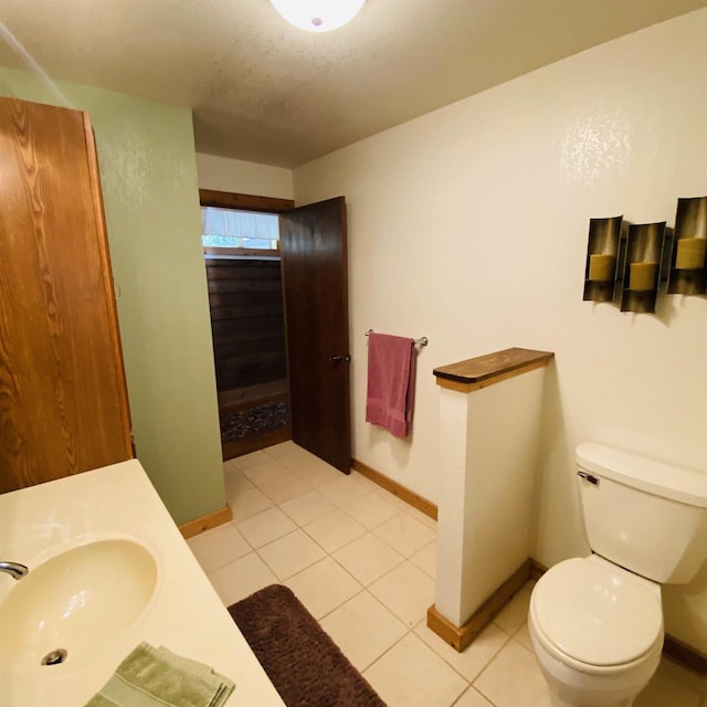 bathroom with toilet, tile floors, and sink