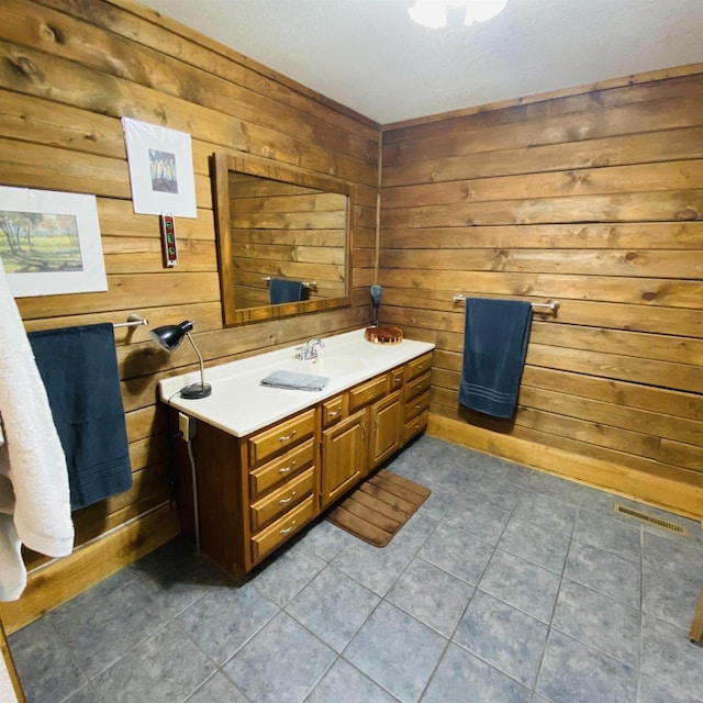 bathroom featuring wood walls, tile floors, and vanity