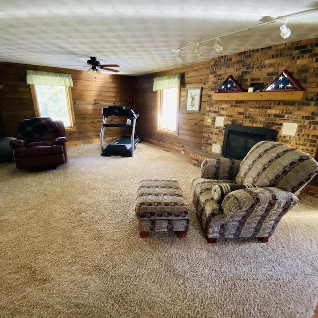 carpeted living room featuring plenty of natural light, ceiling fan, rail lighting, and a fireplace