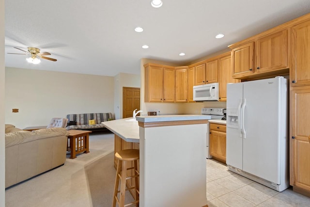 kitchen with light colored carpet, a center island, ceiling fan, white appliances, and a breakfast bar area