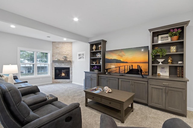 carpeted living room featuring a stone fireplace