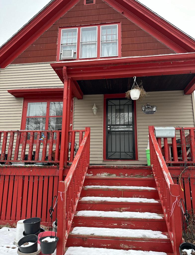 snow covered property entrance featuring covered porch