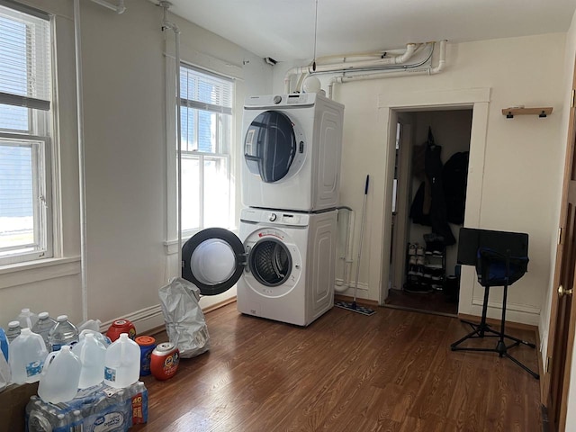 washroom with dark wood-type flooring and stacked washer / drying machine