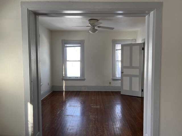 empty room with ceiling fan and dark hardwood / wood-style flooring