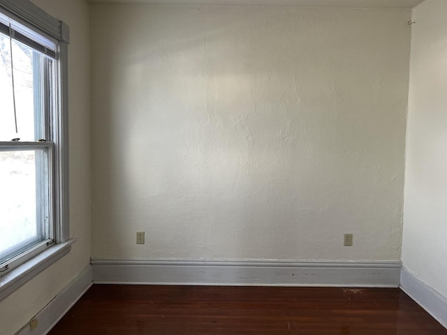 unfurnished room with a healthy amount of sunlight and dark hardwood / wood-style flooring