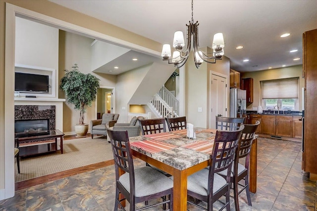 dining space featuring dark tile flooring, an inviting chandelier, and sink