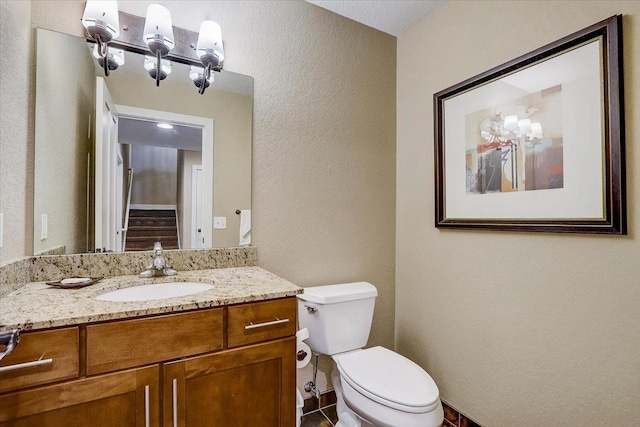 bathroom featuring a textured ceiling, toilet, tile floors, and vanity with extensive cabinet space