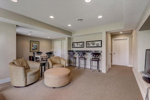 living area featuring carpet flooring and a textured ceiling