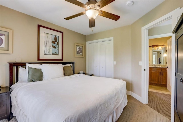 carpeted bedroom featuring ceiling fan, a closet, and ensuite bathroom